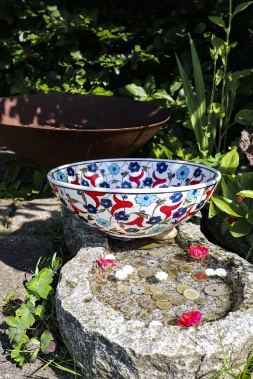 Colorful ceramic bowl in Ottoman style design with bright blue and red colored flowers on a white backdrop. Lead free and ideal for serving fruits and salads.