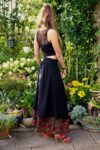 Long boho skirt in black with pockets. Visible underskirt in colorful pattern