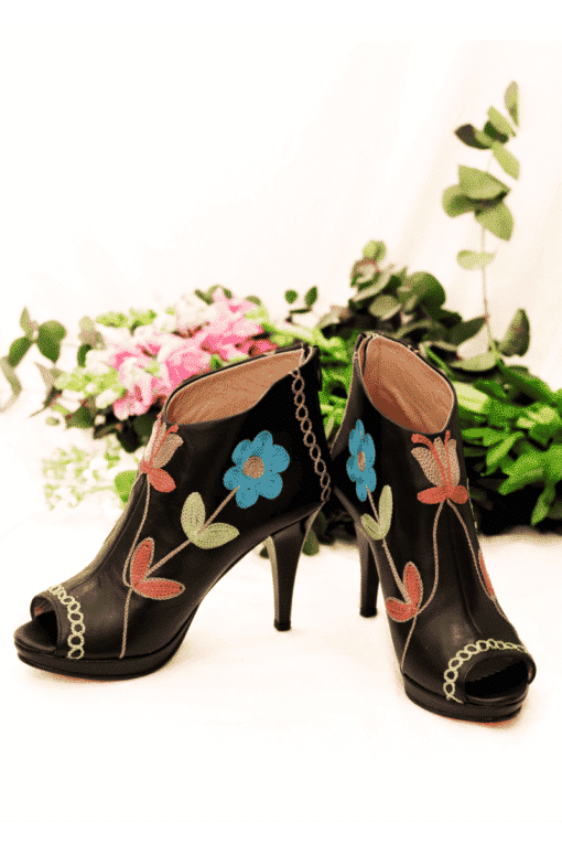 Handmade leather stilettos in black with bright colored floral embroidery.