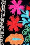 close-up of the floral pattern on a long-shafted boot. Handmade embroidery in Suzani fabrics
