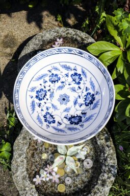 Ceramic bowl from the top with floral blue motifs on a white backdrop