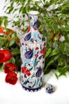 Decorative ceramic bottle suited for food ware. Beautifully illustrated with red and blue flowers. Foodsafe quality