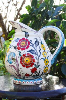 Håndlavet keramikkande med blomster i roede, gule og turkise farver