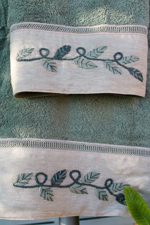 Handmade embroidery in dusty green colors decorating an organic towel set